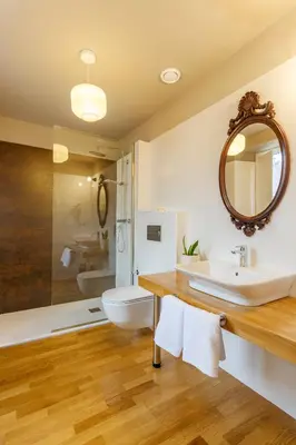 a bathroom with a sink and a toilet and a mirror at Hotel Casa da Galbana in Friol