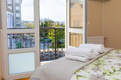 a room with a bed with towels on a balcony at APARTAMENTO RIAMAR - A ESTRENAR in Ribadeo