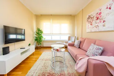 a living room with a pink couch and a tv at APARTAMENTO RIAMAR - A ESTRENAR in Ribadeo