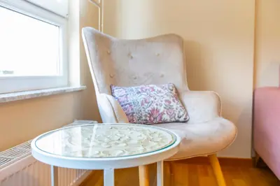a white chair with a glass table and a pillow at APARTAMENTO RIAMAR - A ESTRENAR in Ribadeo