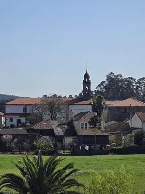 a town with a church with a clock tower at Pensión Pedrouzo in O Pedrouzo