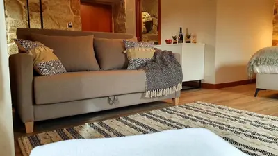 a living room with a couch and a rug at Hotel La Rectoral in Covelo