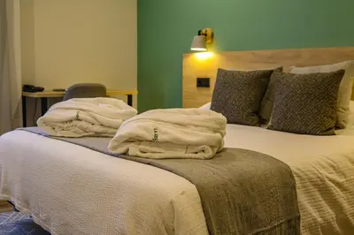 a bedroom with a bed with towels on it at Hotel La Rectoral in Covelo