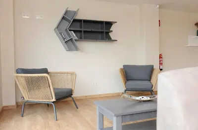 a room with two chairs and a table and a tv at Albergue El Aleman in Boente