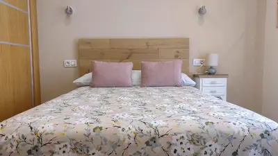 a bed with two pink pillows in a bedroom at APARTAMENTOS TURISTICOS LAS CANDELAS in Puebla de Sanabria