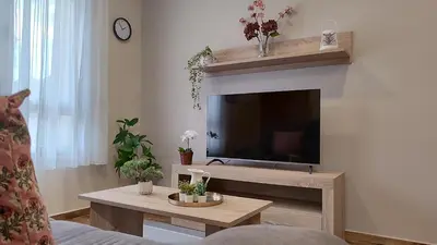 a living room with a flat screen tv on a wall at APARTAMENTOS TURISTICOS LAS CANDELAS in Puebla de Sanabria
