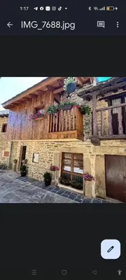 a building with potted plants on the side of it at APARTAMENTOS TURISTICOS LAS CANDELAS in Puebla de Sanabria