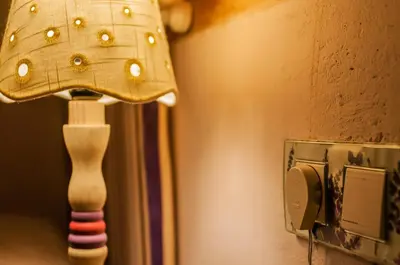 a lamp on a wall next to a lightswitch at Casa Rural El Llao Y Los Fresnos in Murias de Paredes