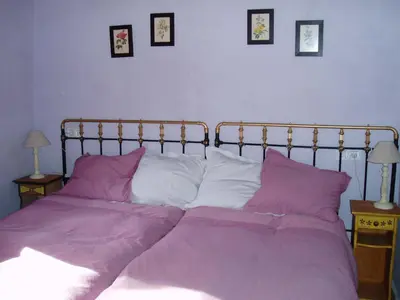 a bedroom with a bed with purple sheets and pillows at Casa Rural El Llao Y Los Fresnos in Murias de Paredes