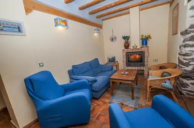 a living room with blue couches and a fireplace at Casa Rural El Llao Y Los Fresnos in Murias de Paredes
