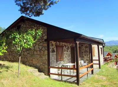 a small cabin with a stone wall at Cabañas Maleixas in El Puente