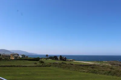 a view of the ocean from the side of a road at Apartamentos Los Gemelos in Foz