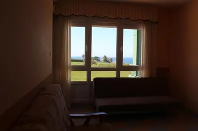a living room with a large window and a couch at Apartamentos Los Gemelos in Foz