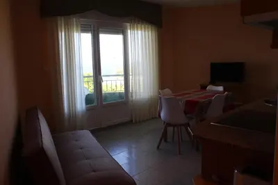 a living room with a table and chairs and a window at Apartamentos Los Gemelos in Foz