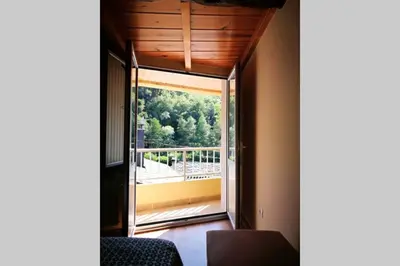 a room with a large window with a view of a balcony at Apartamento con vistas al río A Solaina in Samos