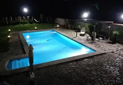 a swimming pool in a yard at night at LE LLAR casa con 2 PISCINAS 1 CLIMATIZADA INTERIOR muy cerca de Santiago de Compostela in Amés