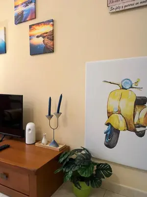 a room with a desk with a painting of a scooter on the wall at S&H La Marimorena in Ribadeo