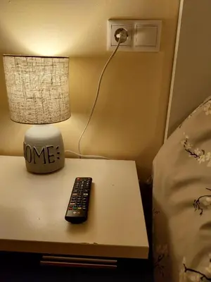 a table with a lamp and a remote control on it at S&H La Marimorena in Ribadeo