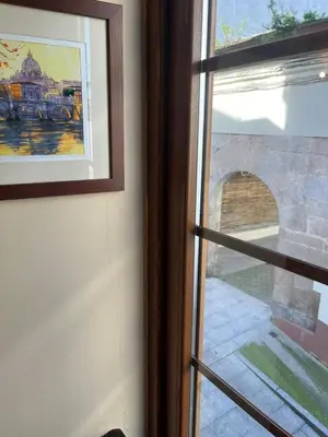 a window with a view of a stone archway at S&H La Marimorena in Ribadeo