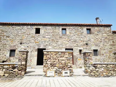 a stone building with a stone wall with windows at Apartamentos C'Ambrosio in La Peral