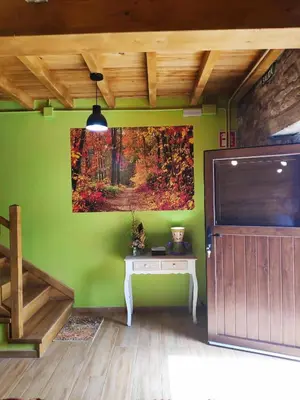 a green room with a table and a painting on the wall at Apartamentos C'Ambrosio in La Peral