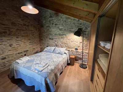 a bedroom with a bed and a brick wall at Casa rural LA TORRE recién rehabilitada. in Las Herrerías