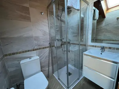 a bathroom with a shower and a toilet and a sink at Casa rural LA TORRE recién rehabilitada. in Las Herrerías