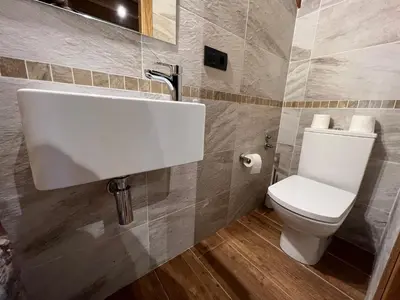 a bathroom with a white sink and a toilet at Casa rural LA TORRE recién rehabilitada. in Las Herrerías