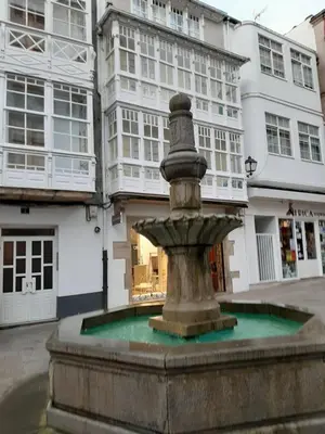 a fountain in the middle of a street with buildings at Alquiler de apartamento en el centro de Viveiro in Viveiro