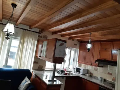 a kitchen with wooden cabinets and a counter top at Alquiler de apartamento en el centro de Viveiro in Viveiro