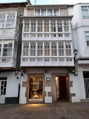 a large white building with a store front at Alquiler de apartamento en el centro de Viveiro in Viveiro