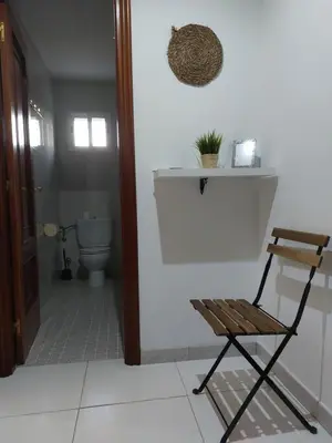 a wooden chair in a bathroom with a toilet at A Taberna de Gundián in Vedra