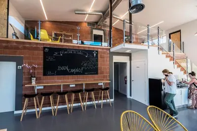 a kitchen with a bar with a brick wall at Albergue Santiago 15 Monforte in Monforte de Lemos