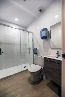 a bathroom with a shower and a toilet and a sink at Albergue Santiago 15 Monforte in Monforte de Lemos