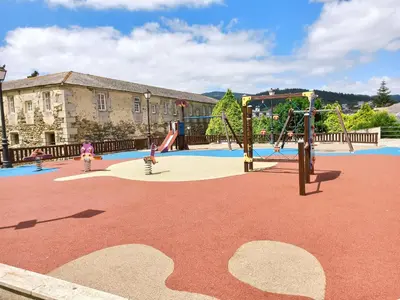 a playground with a slide and swings at Viveiro Histórico in Viveiro