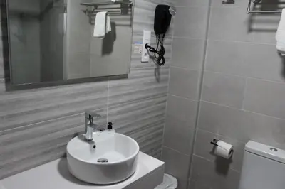 a bathroom with a sink and a toilet and a mirror at Hotel Rego Foz in Foz
