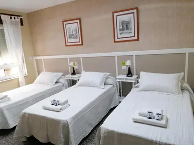 a room with two beds with towels on them at Cuatro Caminos in Sarria