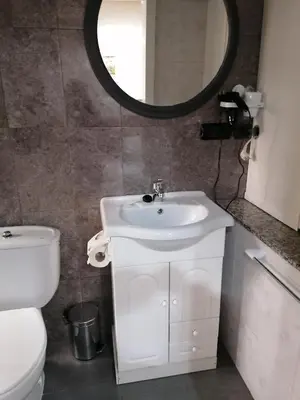 a bathroom with a sink and a toilet and a mirror at Cuatro Caminos in Sarria