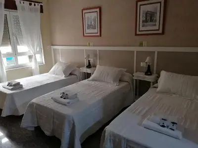 two beds in a hotel room with white sheets at Cuatro Caminos in Sarria