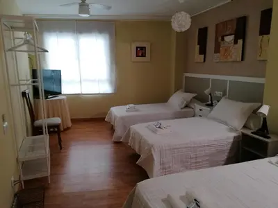 a hotel room with two beds and a television at Cuatro Caminos in Sarria