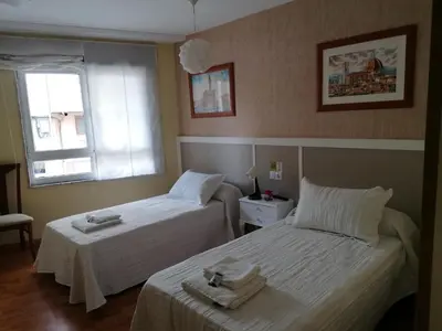 a room with two beds with towels on them at Cuatro Caminos in Sarria