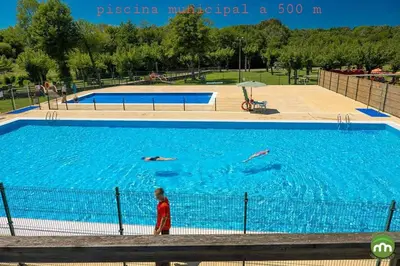 a boy standing in front of a large swimming pool at A Casa do Lado in Melide