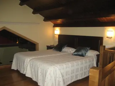 a bedroom with two beds with white sheets at Apartamentos Rurales Romallande in Puerto de Vega