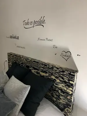 a bedroom with a bed with a sign on the wall at A&M Burela Costa in Burela de Cabo