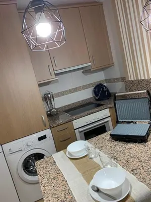 a kitchen with a counter top with a washing machine at A&M Burela Costa in Burela de Cabo
