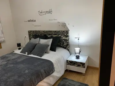 a bedroom with a bed and a sign on the wall at A&M Burela Costa in Burela de Cabo
