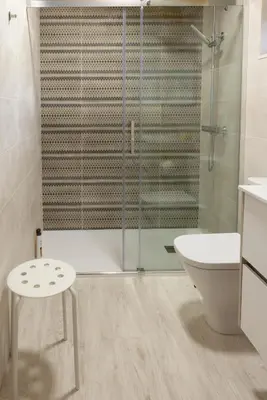 a bathroom with a glass shower and a toilet and a stool at Casa Doade, en A Ribeira Sacra in Doade