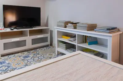 a living room with a white entertainment center with a flat screen tv at Casa Doade, en A Ribeira Sacra in Doade