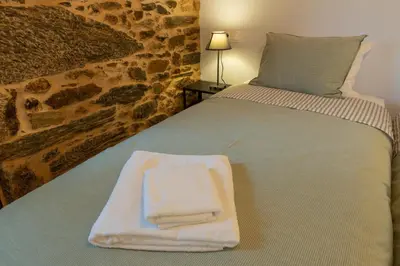 a bed with a white towel on top of it at Casa Doade, en A Ribeira Sacra in Doade