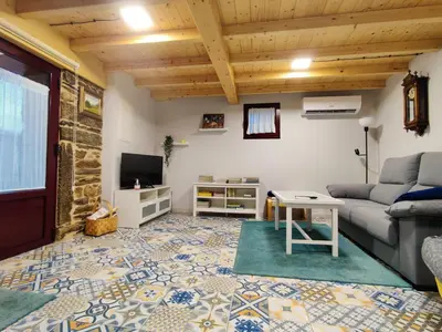 a living room with a couch and a tv at Casa Doade, en A Ribeira Sacra in Doade